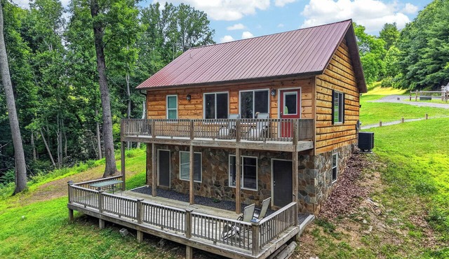 A secluded, multi-level log cabin featuring a spacious wooden deck, open-concept living, a fully equipped modern kitchen, and comfortable sports-themed bunk rooms.